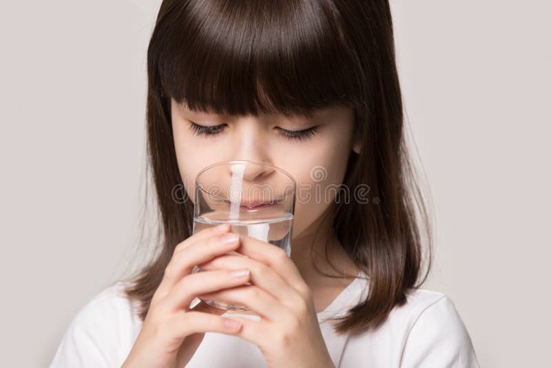 Close up studio portrait little girl hold glass drinking water