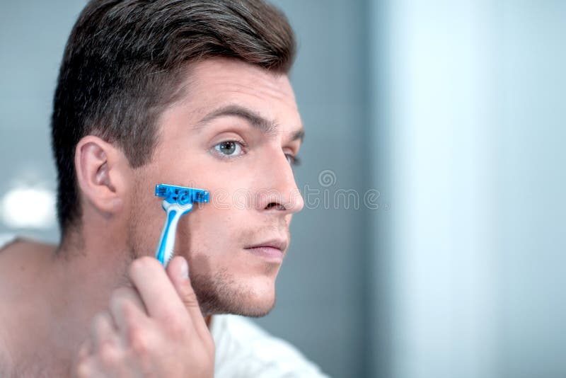 Close up. stylish young man shaves his face. royalty free stock images Close up. stylish young man shaves his face. royalty free stock images
