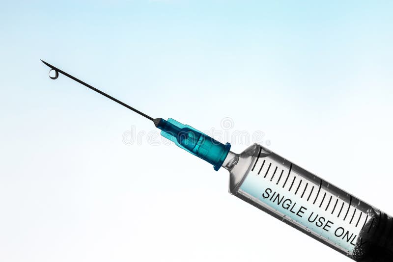 Close-up syringe filled with liquid with air bubbles. Inscription - single use only