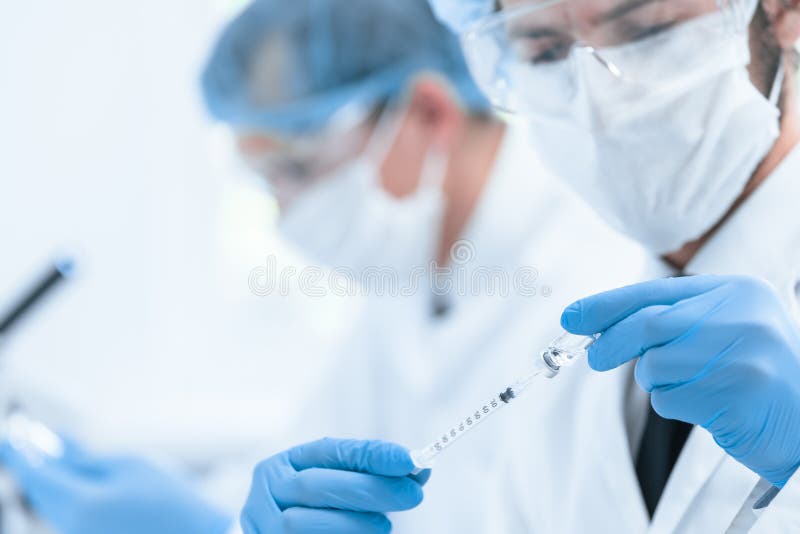 Close up. syringe with a new vaccine in the hands of a medic.