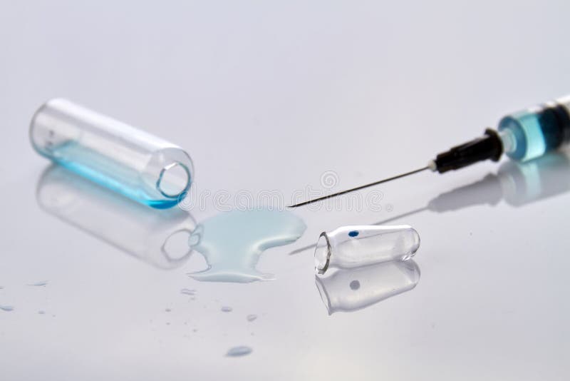 Close up syringe and opened vial ampoules.