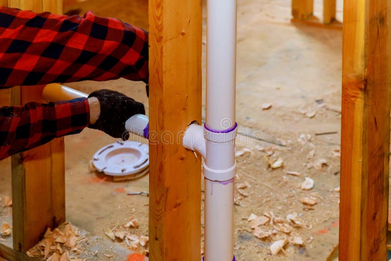 Close up on t joint and pipes for a home sewage system, in wood wall, drain and vent plumbing system stock image Close up on t joint and pipes for a home sewage system, in wood wall, drain and vent plumbing system stock image