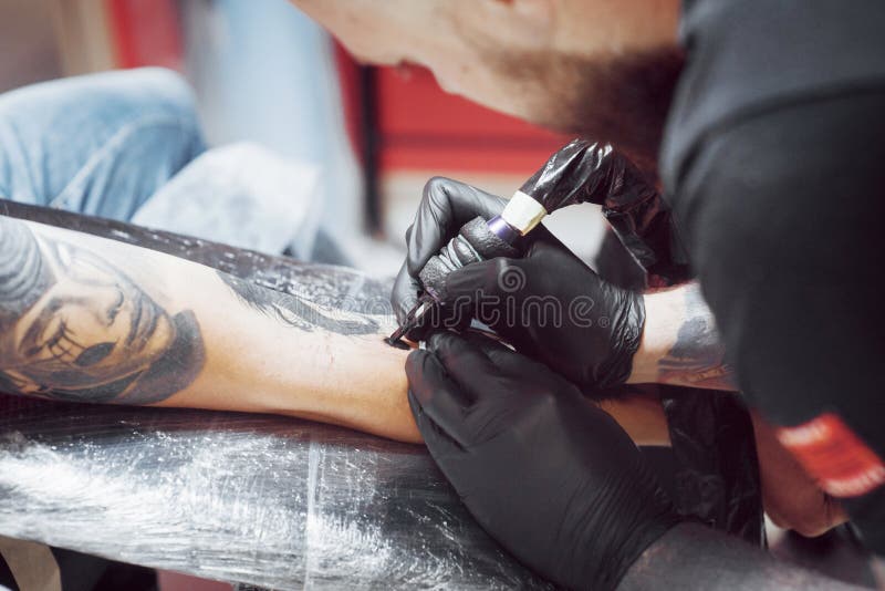 Premium Photo  Close up of a tattoo artist39s hand with black glove and  his tattoo machine body art concept