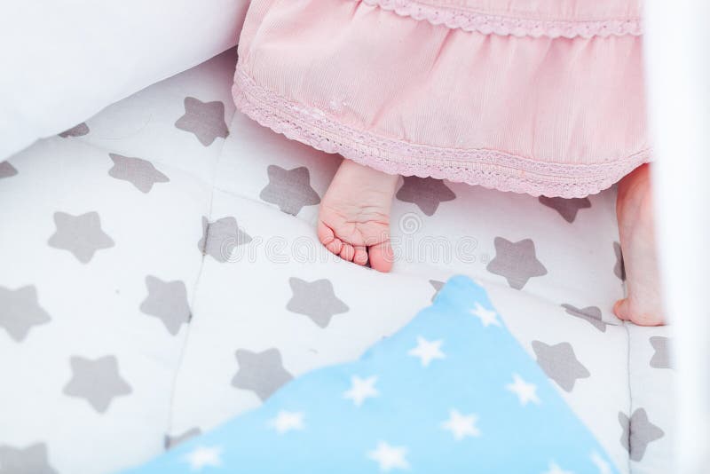 Close Up of Tender Little Feet Crawling on Bed. Pink Soft Blanket is ...