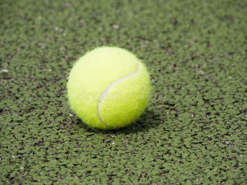 Close-up of tennis ball on green court