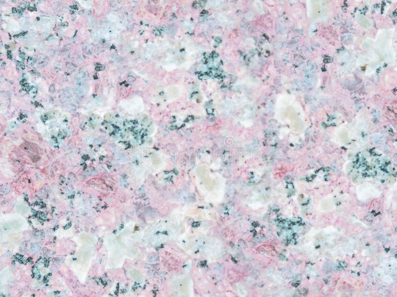 A close-up of a texture of a grinded pale rose granite stone surface