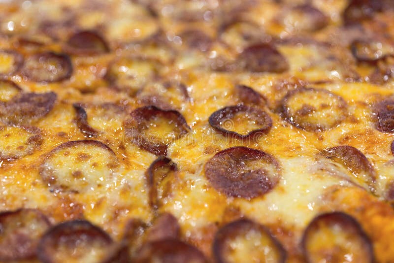 Close up texture of large cheesy pepperoni pizza, background macro stock image