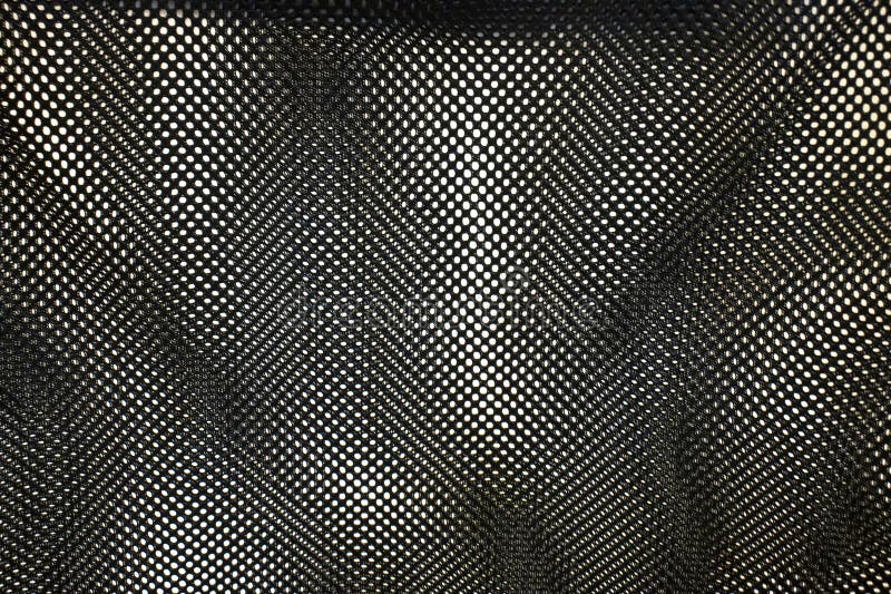Close-up of textured black mesh fabric, showcasing intricate patterns and light play. Ideal for fashion or design projec stock image