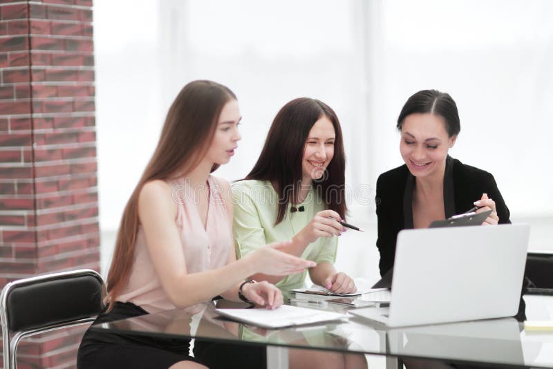 Three Employees with Digital Tablets Sitting on the Steps in the Office