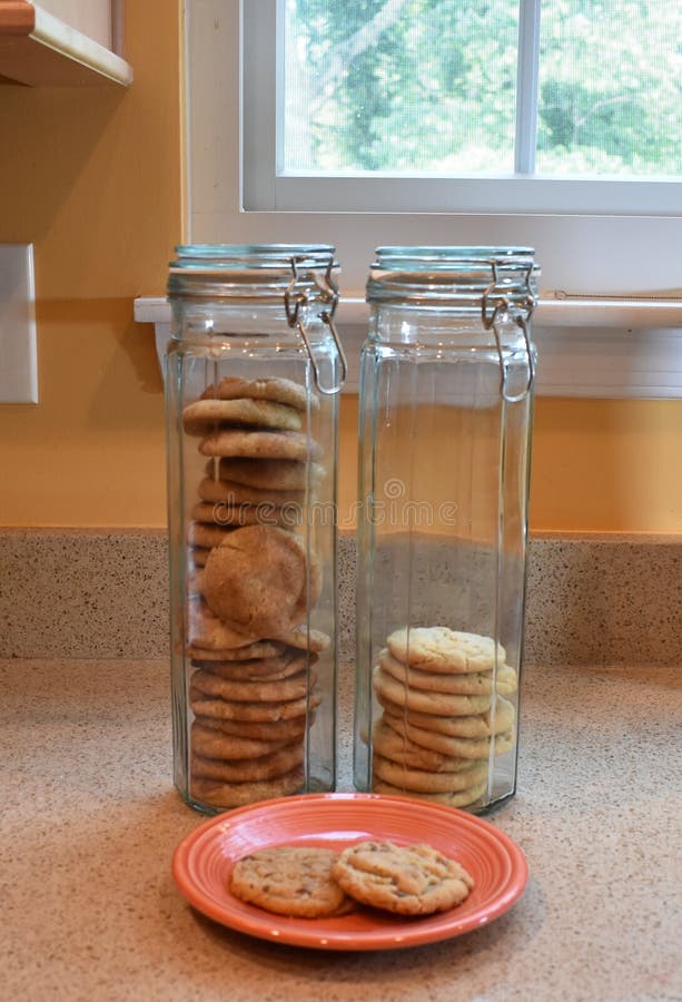 https://thumbs.dreamstime.com/b/close-up-three-homemade-chocolate-chip-cookies-orange-plate-front-two-tall-thin-glass-cookie-jars-standing-side-235007882.jpg