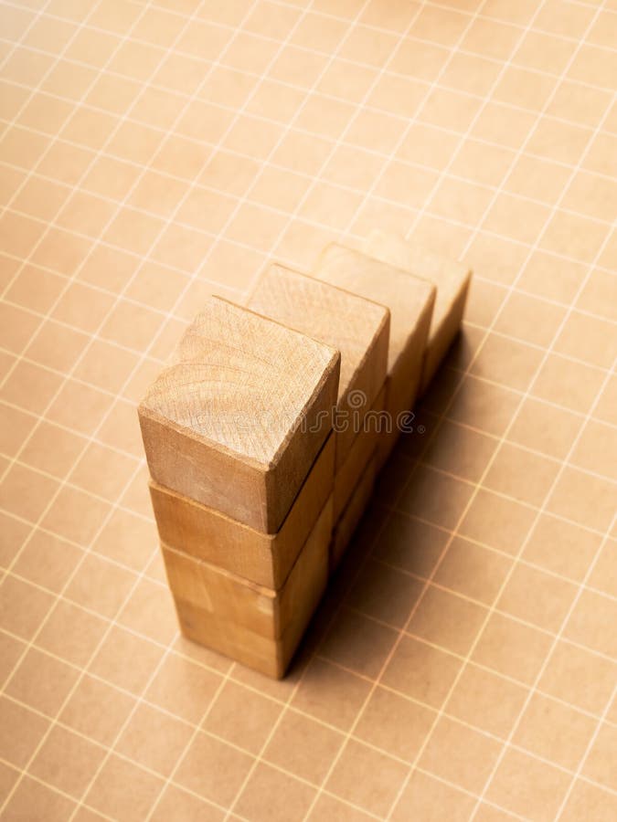Close-up of top of empty blank wooden cube blocks bar graph chart steps on grid pattern and light eco brown background, vertical style. Investment, business growth, highest point of success concepts