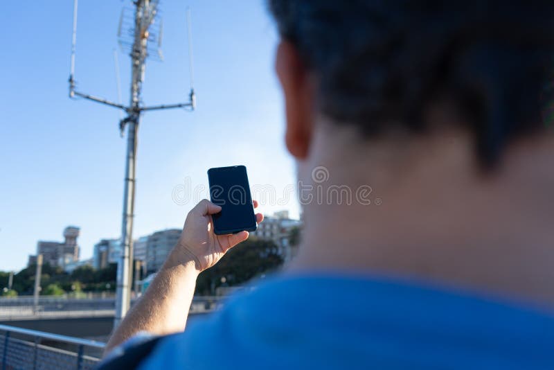 close-up Tourist With No Cellphone data Or Network. Man holding mobile phone and searching for signal internet connection.