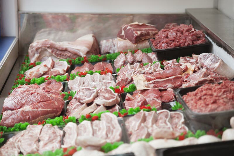 Trays of Raw Meat in the Fridge in a Butcher`s Shop Stock Photo Image