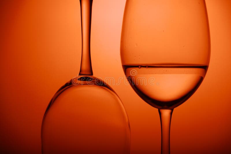 Close-up two wine glasses on orange background