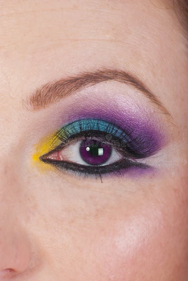 Vista de cerca de una mujer productos cosméticos a extremo púrpura globo ocular.