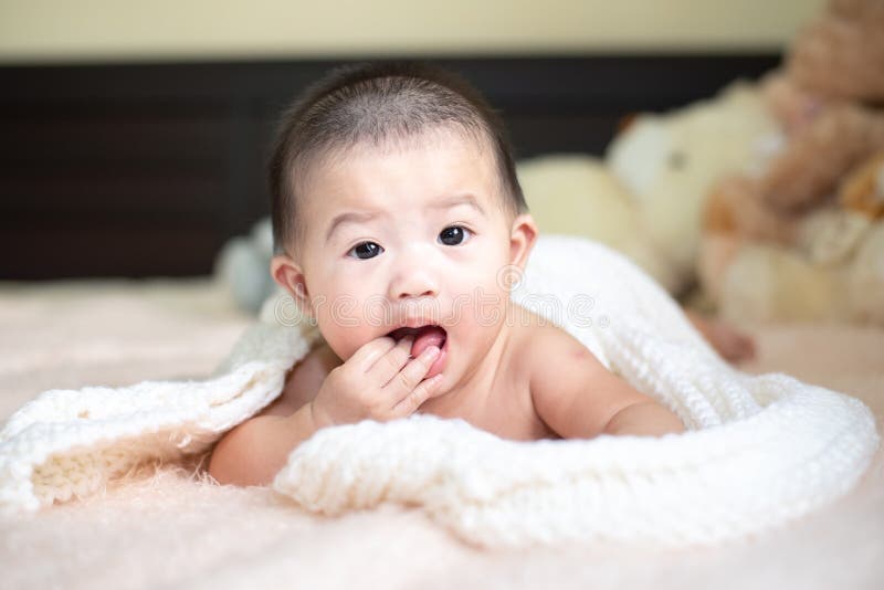 Closeup of Unrecognizable Cute Baby Shaking Feet while Lying in Bed