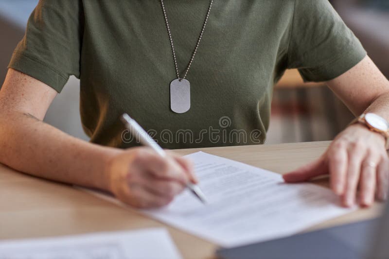 Close up of unrecognizable military woman signing contract in office