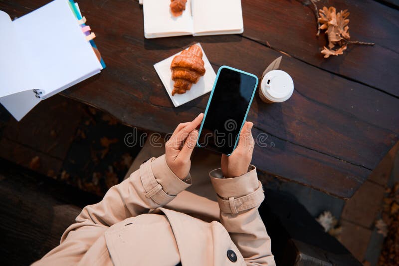 Close-up of an unrecognizable person hands using a mobile phone with blank black screen for copy space on the background of a royalty free stock images