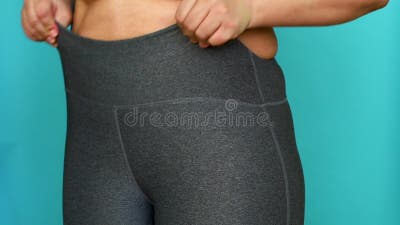 Close-up of Unrecognizable Plump Woman Wearing Beige Underwear, Pulling on  Grey Leggings on Belly on Blue Background. Stock Video - Video of pants,  clothing: 246617401