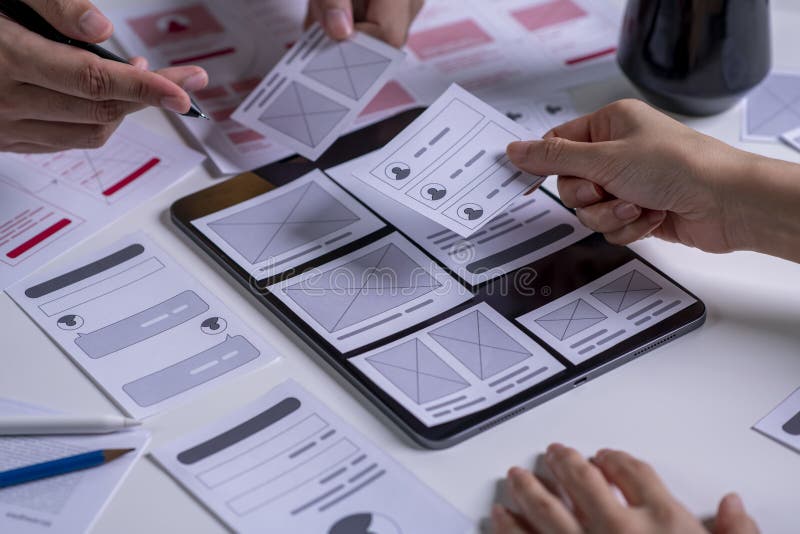 Close up UX developer and ui designer brainstorming about mobile app interface wireframe design on table stock photography
