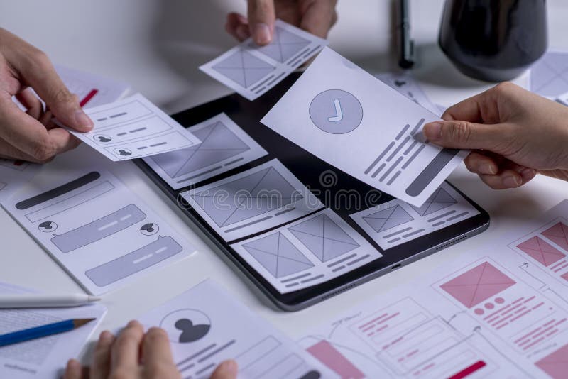 Close up UX developer and ui designer brainstorming about mobile app interface wireframe design on table royalty free stock photography