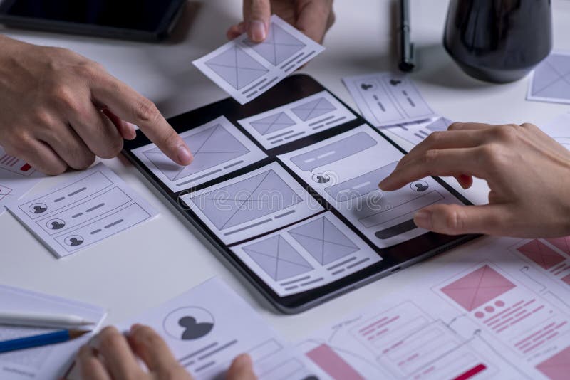Close up UX developer and ui designer brainstorming about mobile app interface wireframe design on table stock image