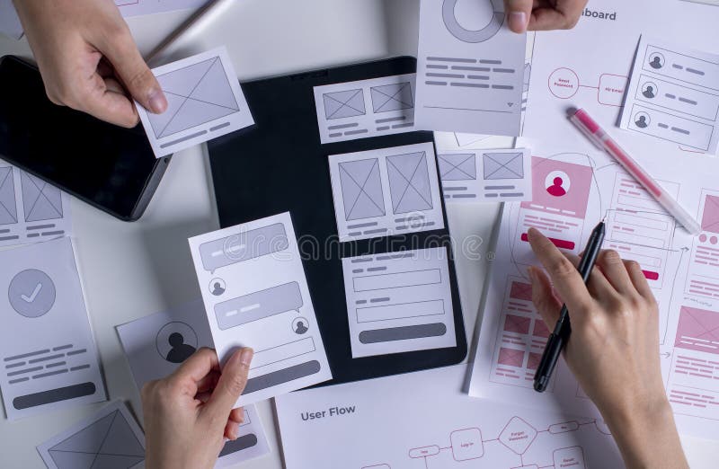 Close up UX developer and UI designer brainstorming about mobile app interface wireframe design on table stock photo