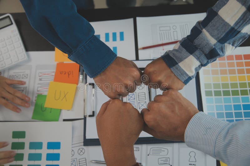 Close up ux developer and ui designer brainstorming about mobile app interface wireframe design on table with customer breif and stock photography