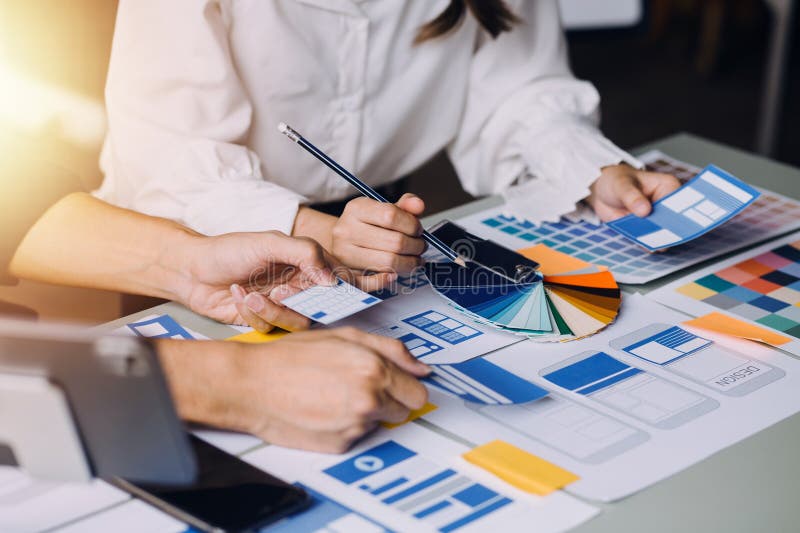 Close up ux developer and ui designer brainstorming about mobile app interface wireframe design on table with customer breif and royalty free stock photos