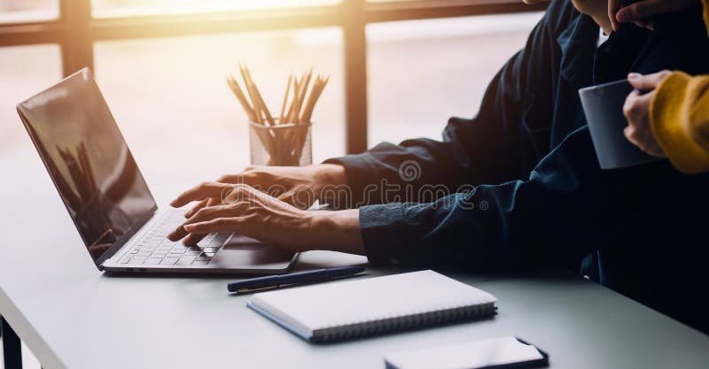 Close up ux developer and ui designer brainstorming about mobile app interface wireframe design on table with customer breif and stock photos