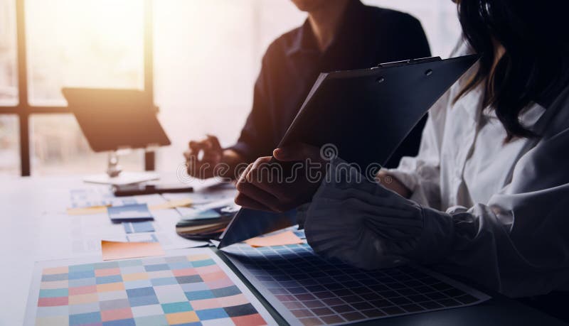 Close up ux developer and ui designer brainstorming about mobile app interface wireframe design on table with customer breif and royalty free stock photography
