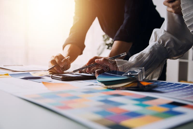 Close up ux developer and ui designer brainstorming about mobile app interface wireframe design on table with customer breif and royalty free stock image