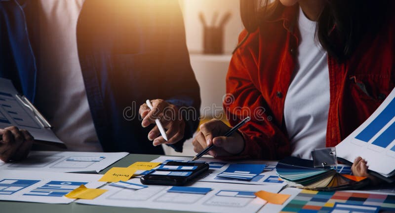 Close up ux developer and ui designer brainstorming about mobile app interface wireframe design on table with customer breif and royalty free stock images