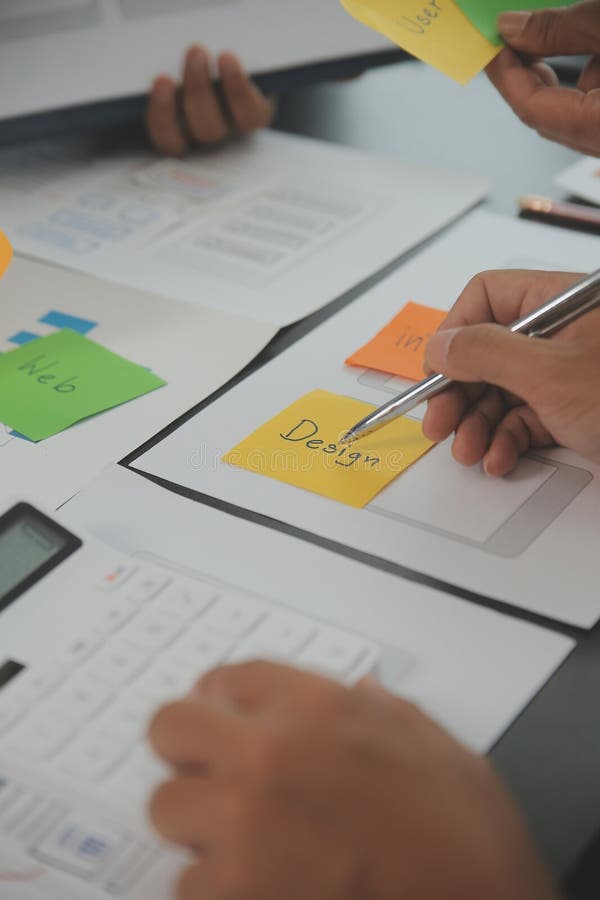 Close up ux developer and ui designer brainstorming about mobile app interface wireframe design on table with customer breif and royalty free stock images