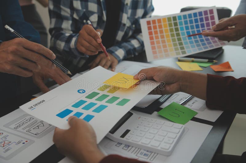 Close up ux developer and ui designer brainstorming about mobile app interface wireframe design on table with customer breif and royalty free stock photography