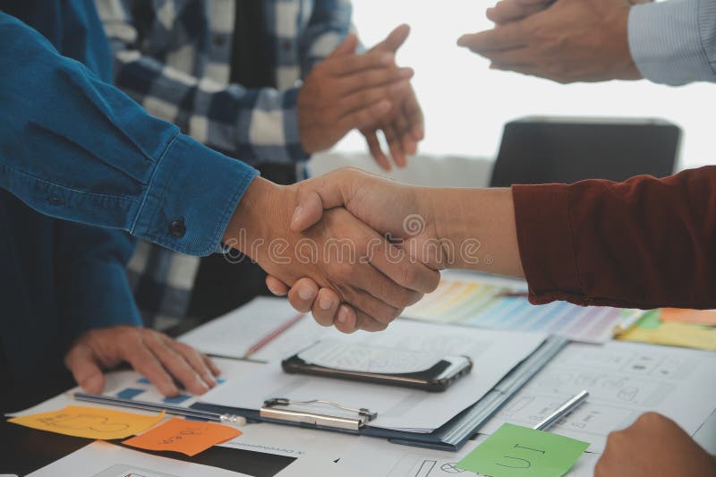 Close up ux developer and ui designer brainstorming about mobile app interface wireframe design on table with customer breif and royalty free stock image