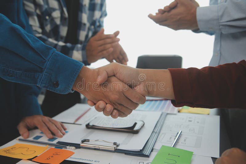 Close up ux developer and ui designer brainstorming about mobile app interface wireframe design on table with customer breif and royalty free stock images
