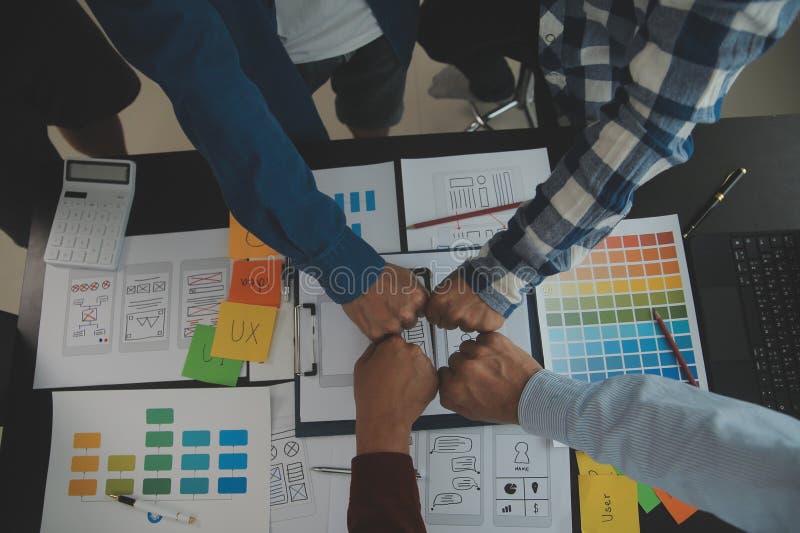 Close up ux developer and ui designer brainstorming about mobile app interface wireframe design on table with customer breif and royalty free stock photo