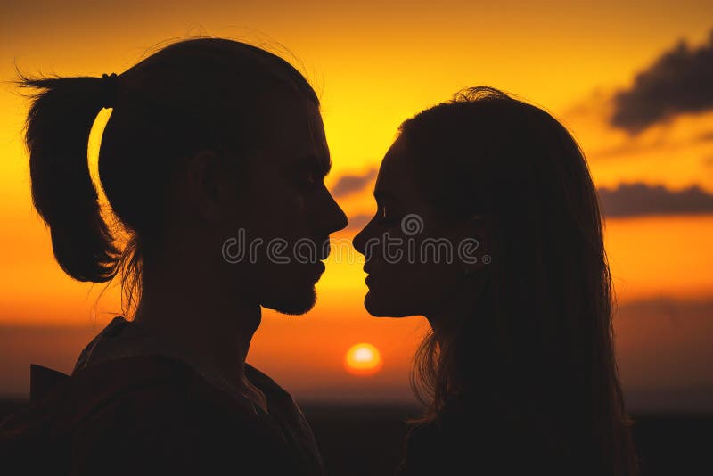 Close-up van de silhouetten van een jong millenial paar in liefde met een mens en een meisje tegen de zonsondergang gouden hemel royalty-vrije stock afbeeldingen Close-up van de silhouetten van een jong millenial paar in liefde met een mens en een meisje tegen de zonsondergang gouden hemel royalty-vrije stock afbeeldingen