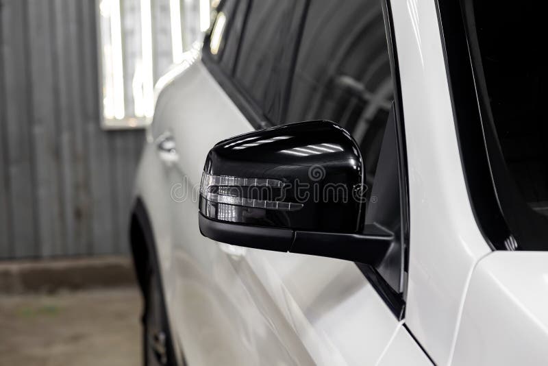 Close-up van de zwarte zijspiegel van het autolichaam in het ontwerp van een witte suv stock foto Close-up van de zwarte zijspiegel van het autolichaam in het ontwerp van een witte suv stock foto