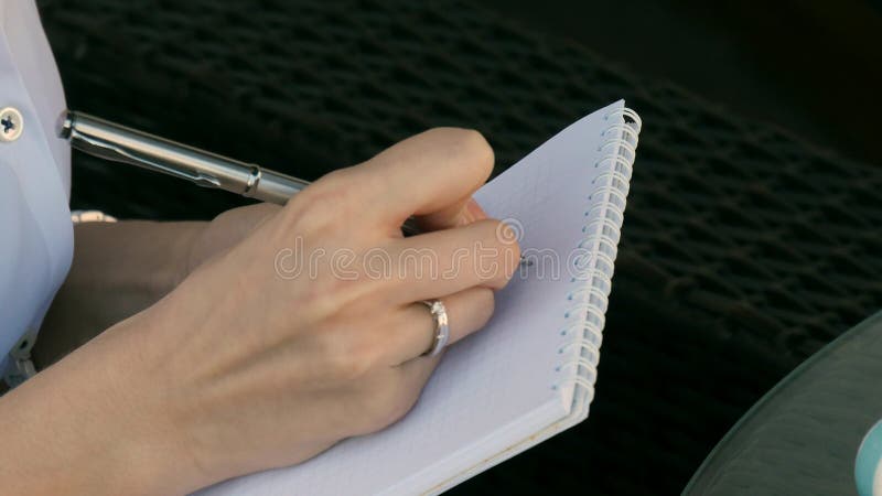 Close-up van een meisje die in een notitieboekje schrijven royalty-vrije stock foto's Close-up van een meisje die in een notitieboekje schrijven royalty-vrije stock foto's