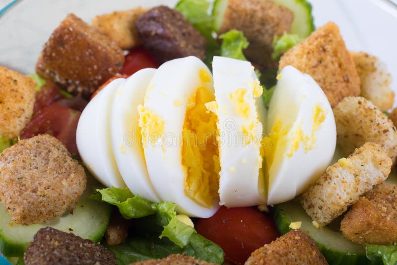 Close-up van gekookt ei dat slecht bovenop een salade werd gesneden