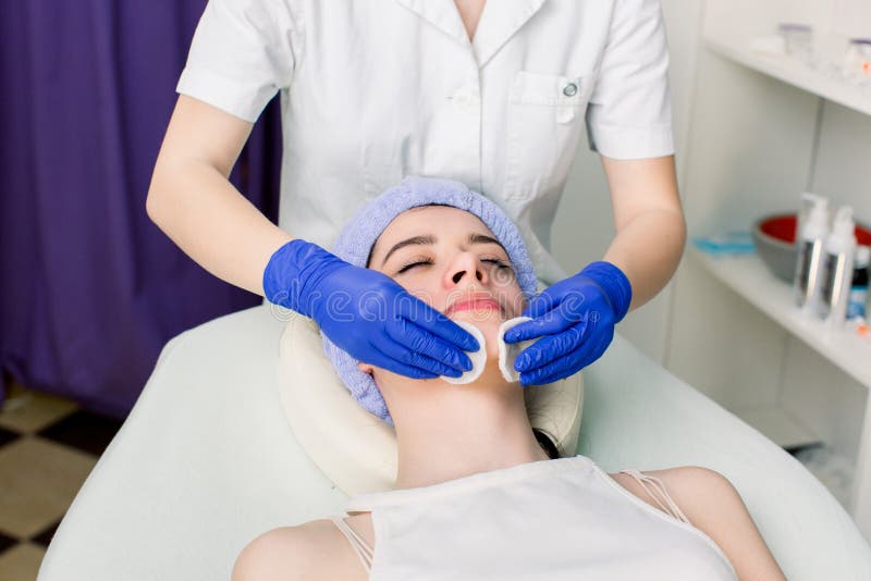 Close-up van gezicht die van vrouw op laag liggen en tijdens kosmetische procedure in de kosmetieksalon ontspannen Handen van wij royalty-vrije stock afbeeldingen Close-up van gezicht die van vrouw op laag liggen en tijdens kosmetische procedure in de kosmetieksalon ontspannen Handen van wij royalty-vrije stock afbeeldingen