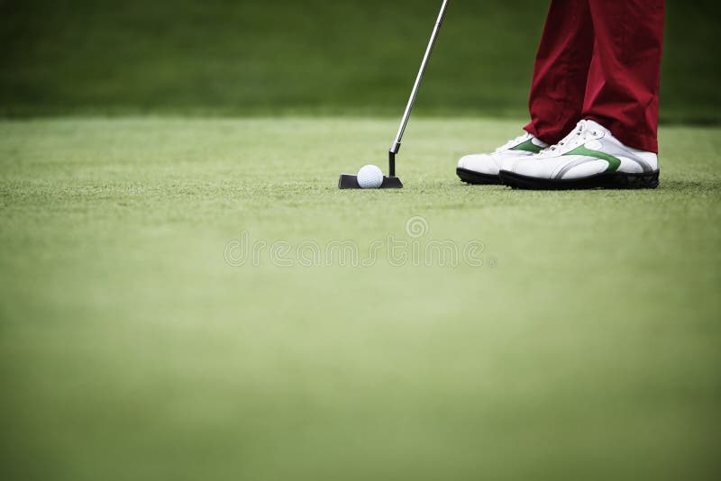 Feet of female golf player putting at green, with plenty of copy-space. Feet of female golf player putting at green, with plenty of copy-space.