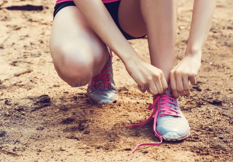 Close-up van kant van de vrouwen het bindende schoen Vrouwelijke sportfitness agent die klaar voor jogging in openlucht op bosweg stock afbeeldingen Close-up van kant van de vrouwen het bindende schoen Vrouwelijke sportfitness agent die klaar voor jogging in openlucht op bosweg stock afbeeldingen