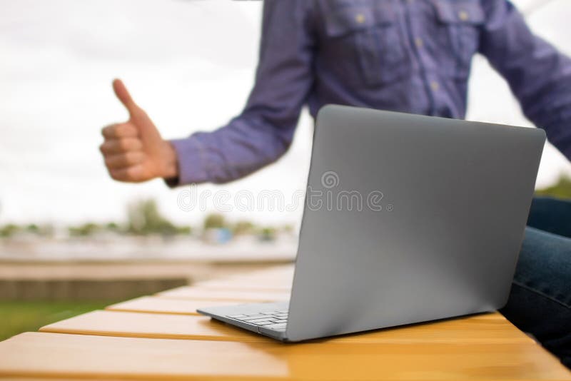 Close-up van Laptop Laptop op een bank op een vage achtergrond Jonge mens die een duim tot laptop geven De ruimte van het exempla stock afbeeldingen Close-up van Laptop Laptop op een bank op een vage achtergrond Jonge mens die een duim tot laptop geven De ruimte van het exempla stock afbeeldingen
