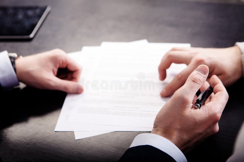 Close-up van mannelijke hand die richten waar te een contract, wettelijk documenten of een aanvraagformulier te ondertekenen