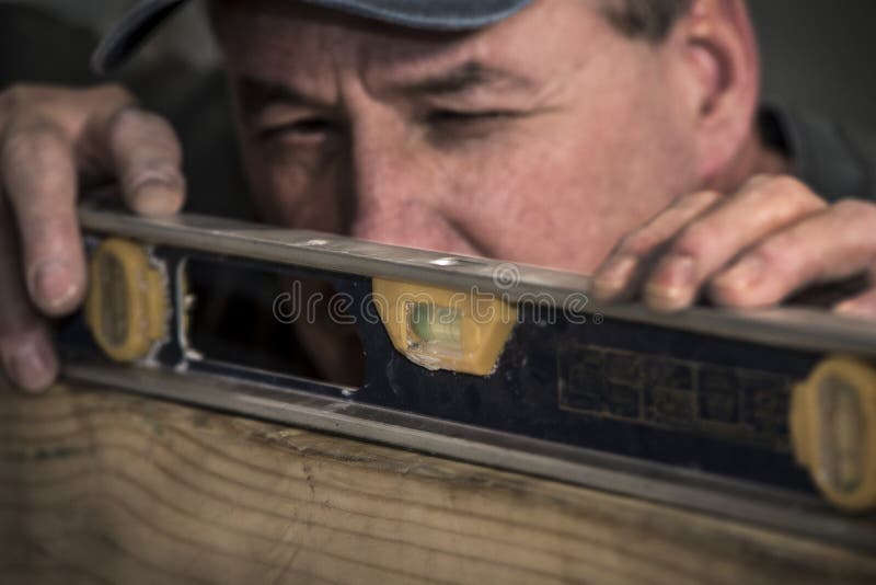 Close-up van mannelijke timmerman die niveauhulpmiddel op houten raad met behulp van stock foto Close-up van mannelijke timmerman die niveauhulpmiddel op houten raad met behulp van stock foto