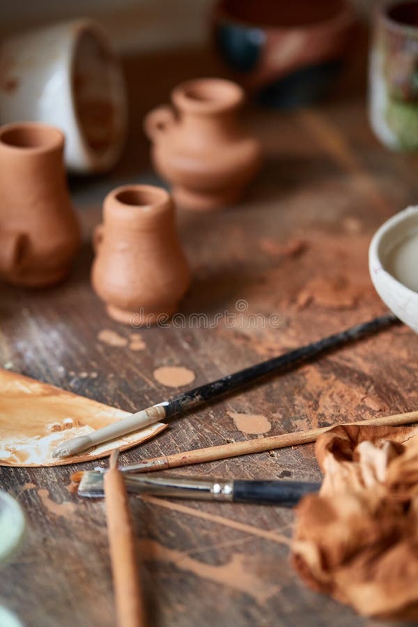 Closeup of Various Paint Mugs and Brushes in Holder on Worktop