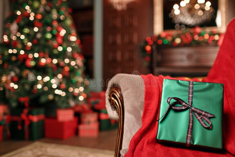 Close-up verde do presente do Natal no primeiro plano Curva da fita vermelha Fundo abstrato com luzes e a árvore borradas cópia fotografia de stock Close-up verde do presente do Natal no primeiro plano Curva da fita vermelha Fundo abstrato com luzes e a árvore borradas cópia fotografia de stock
